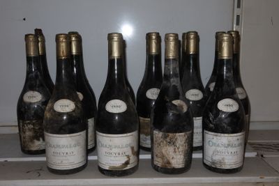 Plusieurs bouteilles de vin sont alignées sur une étagère devant un réfrigérateur