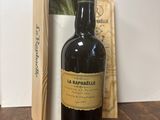 une bouteille de vin posée sur une table à côté d'une boîte