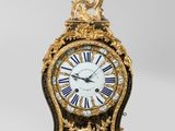 une image représentant une horloge dorée et noire posée sur une table