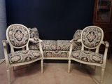two chairs and a couch in a room with a blue wall
