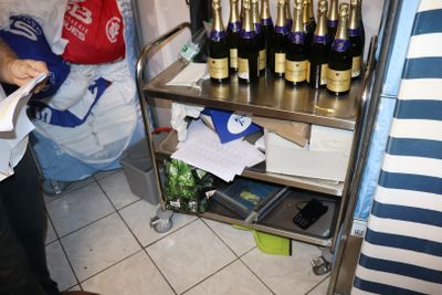 une femme debout devant une étagère où sont rangées des bouteilles de vin
