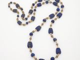 un collier composé de perles de lapis-lazuli et d'or sur fond blanc