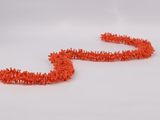a close up of a pair of orange pipe cleaners on a white surface