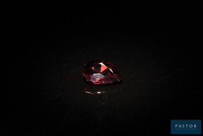 un diamant rouge sur une surface noire