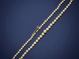 a pearl necklace with a gold clasp on a blue background