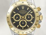 une photo d'une montre en or et en argent avec un cadran noir