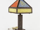 un gros plan d'une lampe posée sur une table, dont le cordon est branché
