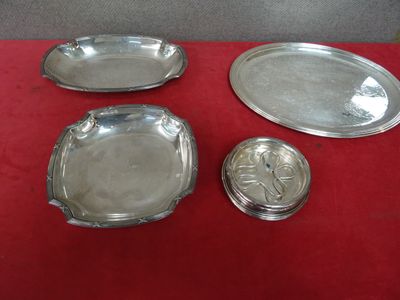 trois plateaux en argent posés sur une table rouge, recouverts d'un couvercle en argent