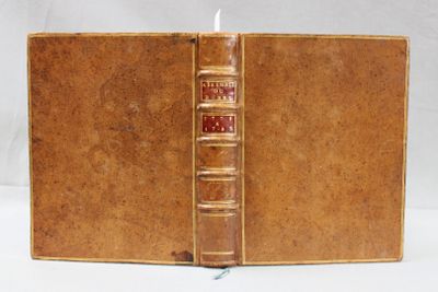 un vieux livre contenant une bougie, posé sur une table