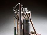 une vieille maquette de machine à vapeur posée sur un socle en bois