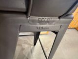 a close up of a black chair with a button on it