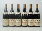 six bouteilles de vin sont alignées sur une table