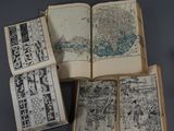 plusieurs livres ouverts, sur lesquels figurent des dessins, posés sur une table