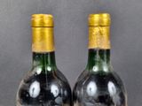 two bottles of wine sitting next to each other on top of a table