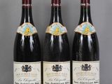 trois bouteilles de vin rouge sont alignées sur une table
