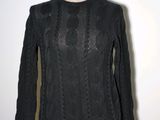 the sweater is black and has long sleeves and a round neck