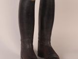 an old pair of brown leather riding boots on a white background
