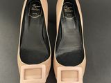 a pair of nude colored shoes with a bow on the heel