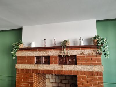 une cheminée en briques dans un salon aux murs verts