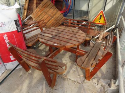 a wooden table and four chairs in the sand