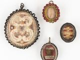 trois pendentifs de formes et de tailles variées sont exposés sur une surface blanche
