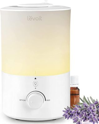 un gros plan d'un diffuseur avec des fleurs de lavande à côté