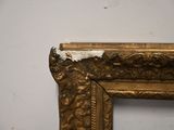 a picture of a gold frame with a white wall in the background