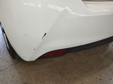 the rear end of a white car in a garage