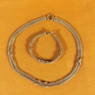 a close up of a necklace and bracelet on a yellow surface
