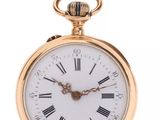 a close up of a gold pocket watch with roman numerals