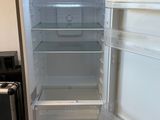 an empty refrigerator with its door open in a kitchen