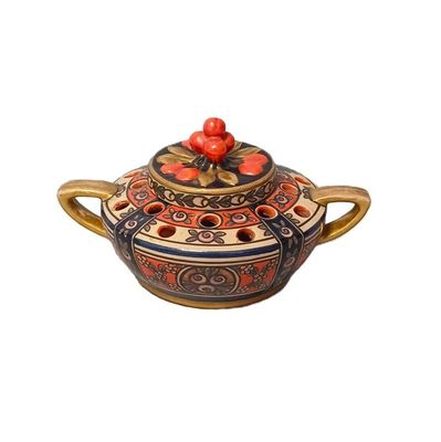 an image of a ceramic teapot with a red flower on top