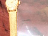 une montre en or posée sur un sac en plastique transparent