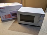 two microwaves sitting on a counter top next to each other