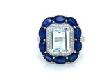 a close up of a ring with an emerald and blue sapphire