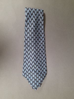a tie that is laying on a table next to a cup