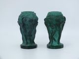 two green vases sitting next to each other on a white surface