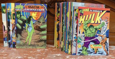 Trois albums de BD sont alignés sur un lit à tête de lit en bois