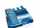 La couverture rayée bleue et blanche est pliée sur une surface blanche.