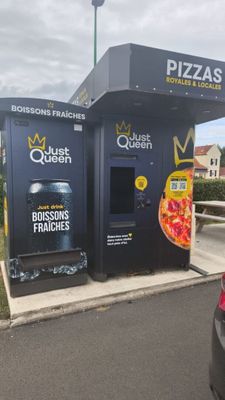 a pizza machine that is sitting on the side of the road