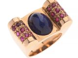 un gros plan d'une bague ornée d'une pierre bleue entourée de pierres roses