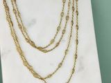 un gros plan d'un collier en or posé sur une surface en marbre