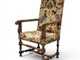 an old chair with a floral upholstered seat and wooden legs