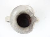 a white vase that has a black substance in it