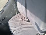 a car with a seat cover and a seat belt in the back