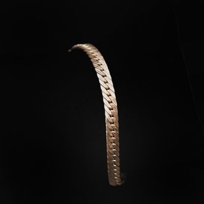 gros plan d'un bracelet en or sur fond noir