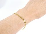 someone is wearing a gold bracelet with a crescent charm on it