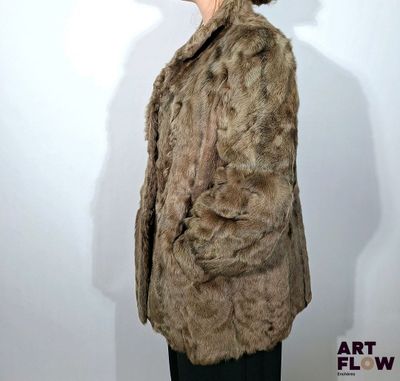 une femme vêtue d'un manteau de fourrure et d'un chapeau, posant pour une photo