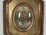 tableau représentant un vase de fleurs dans un cadre doré, accroché à un mur blanc