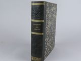 a black and gold book sitting on top of a white table